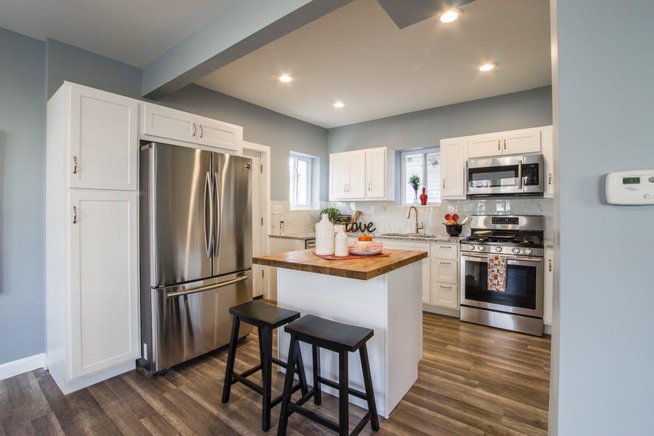 Two Black Wooden Bar Stools Near Table and French-door Refrigerator